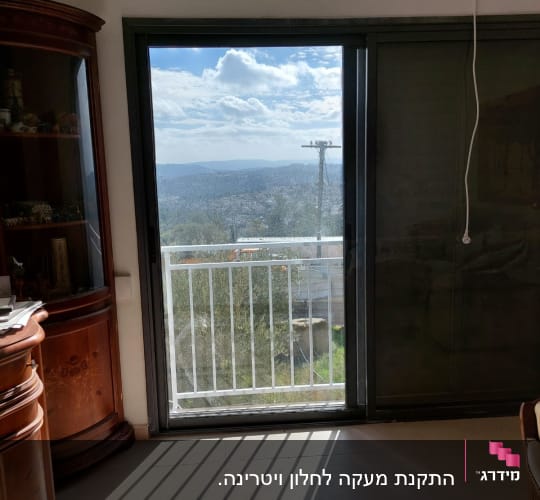 נוף מבעד לחלון עם מסגרת מתכתית.